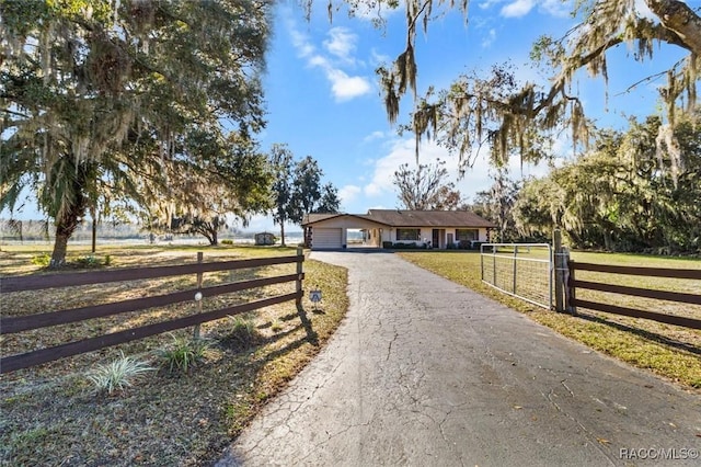 view of front of house with driveway, a front lawn, an attached garage, and fence