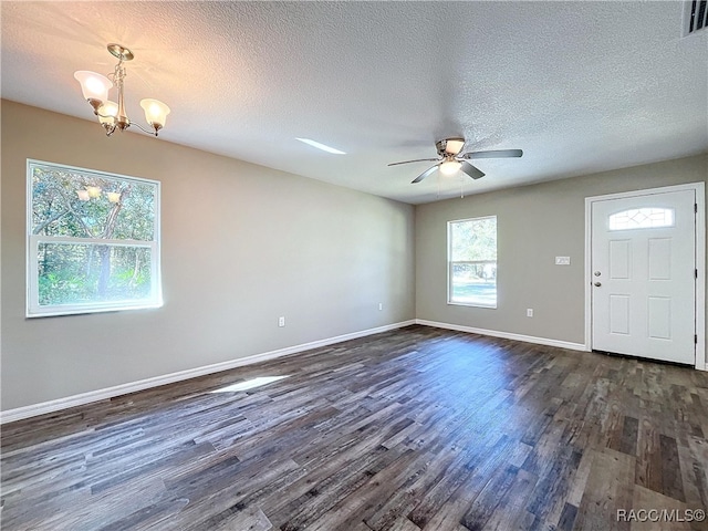 foyer entrance with ceiling fan with notable chandelier, dark wood-type flooring, and a textured ceiling