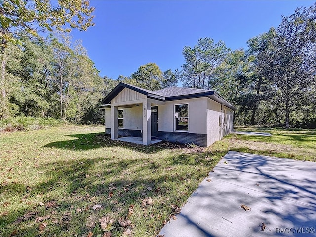 view of side of property with a patio area and a yard