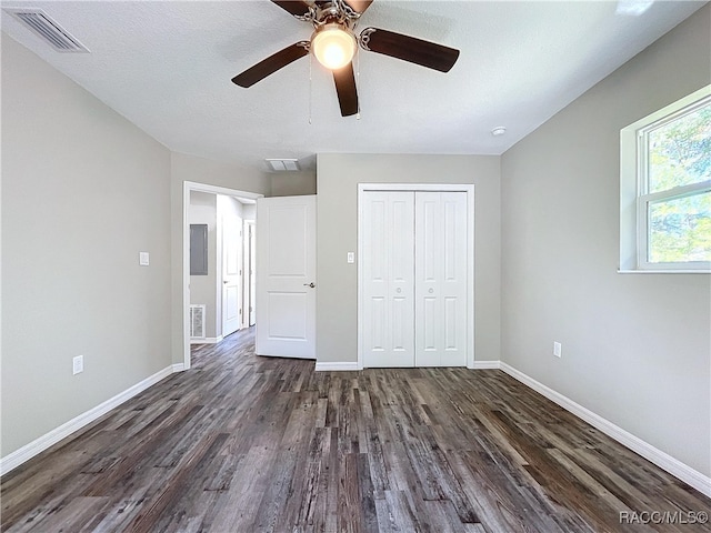 unfurnished bedroom with ceiling fan, a closet, and dark hardwood / wood-style floors