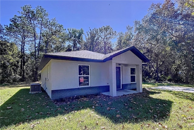 view of front of home featuring a front yard and central AC unit