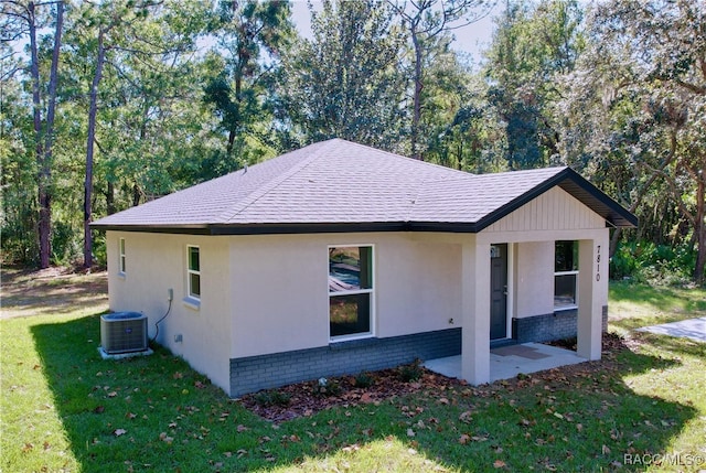 exterior space featuring central AC unit and a lawn