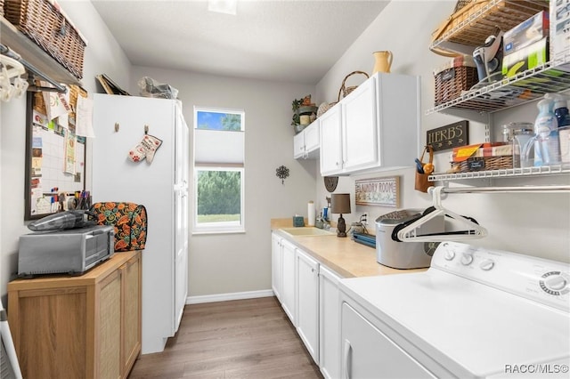 2056 W Learwood Pl, Beverly Hills, FL 34465 - laundry room featuring washer / clothes dryer, cabinet space, light wood finished floors, and baseboards