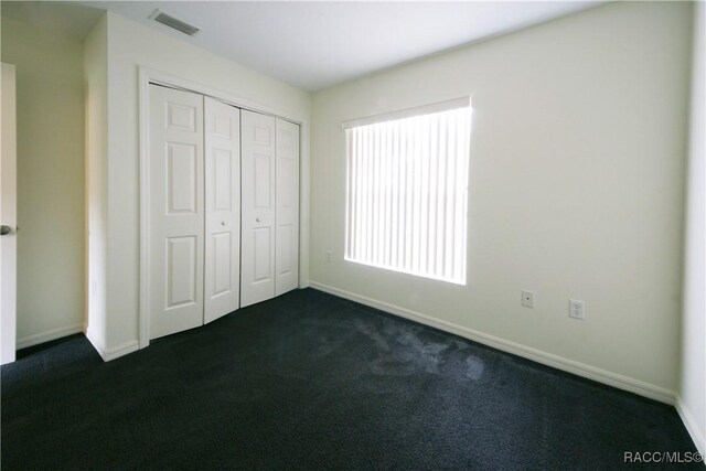 4450 E Windmill Dr Unit 106, 107, 206, 207, Inverness, FL 34453 - unfurnished bedroom featuring dark colored carpet, a closet, and baseboards