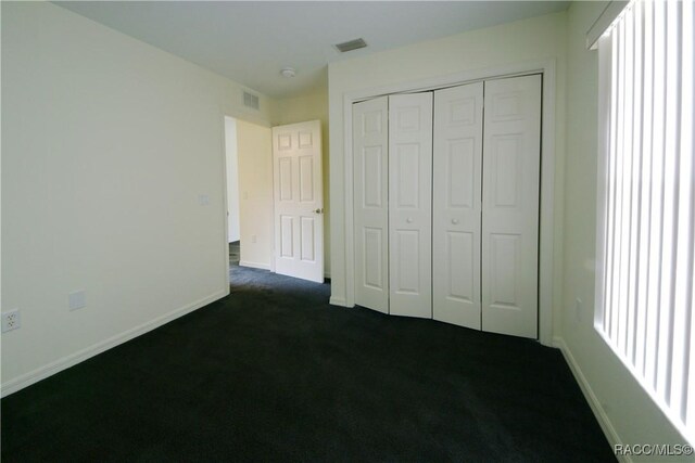 4450 E Windmill Dr Unit 106, 107, 206, 207, Inverness, FL 34453 - unfurnished bedroom with dark colored carpet, baseboards, and a closet