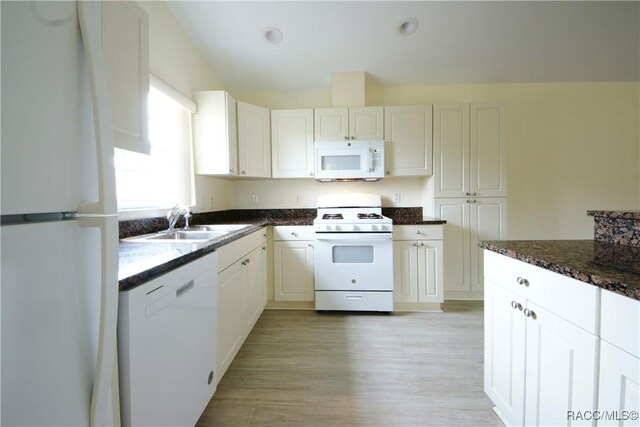 4450 E Windmill Dr Unit 106, 107, 206, 207, Inverness, FL 34453 - kitchen featuring white appliances, a sink, light wood-style flooring, dark stone countertops, and white cabinetry