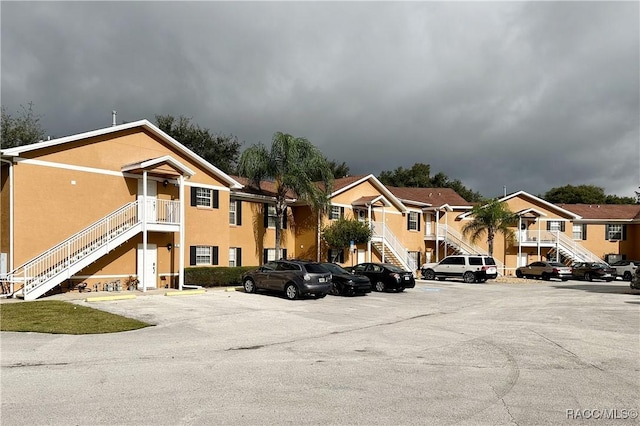 4450 E Windmill Dr Unit 106, 107, 206, 207, Inverness, FL 34453 - view of property featuring stairway, uncovered parking, and a residential view