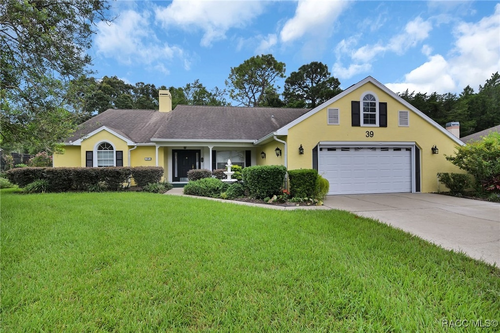 view of front of house featuring a garage and a front lawn