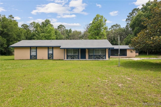 ranch-style home with stucco siding, a front yard, and a sunroom