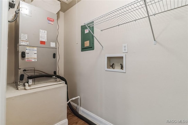 laundry room featuring electric panel, heating unit, baseboards, hookup for a washing machine, and laundry area