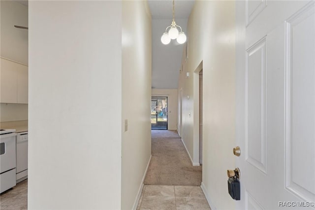 hall featuring light colored carpet and a notable chandelier