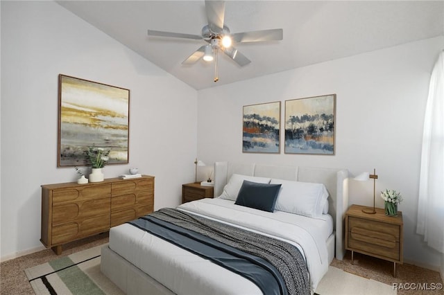 carpeted bedroom with ceiling fan and vaulted ceiling