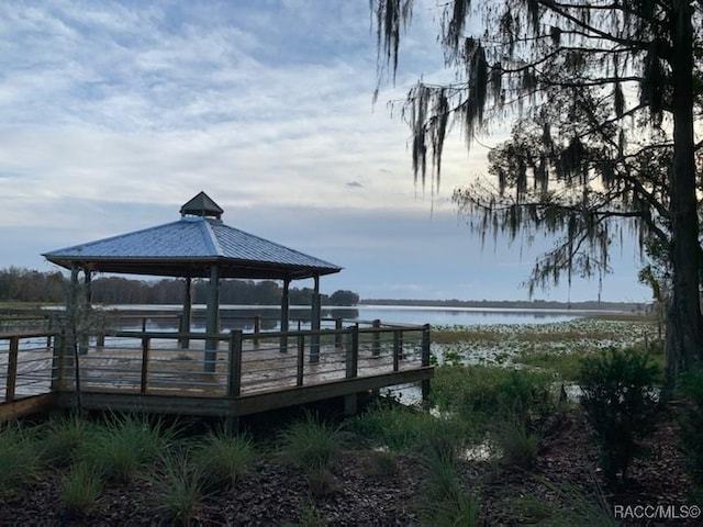 view of dock with a gazebo and a water view