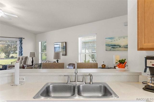 kitchen featuring ceiling fan, a sink, open floor plan, light countertops, and vaulted ceiling