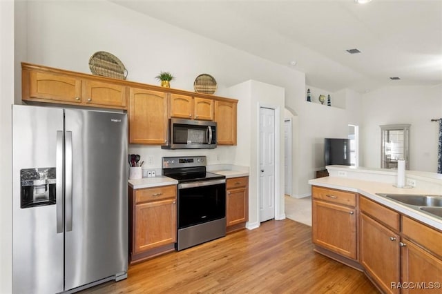 kitchen with visible vents, arched walkways, vaulted ceiling, stainless steel appliances, and light countertops