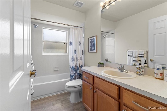 full bathroom featuring visible vents, toilet, shower / bath combo with shower curtain, vanity, and wood finished floors