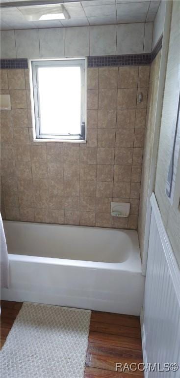 bathroom featuring wood-type flooring and tiled shower / bath