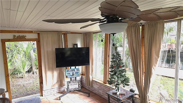 unfurnished sunroom with ceiling fan and wood ceiling