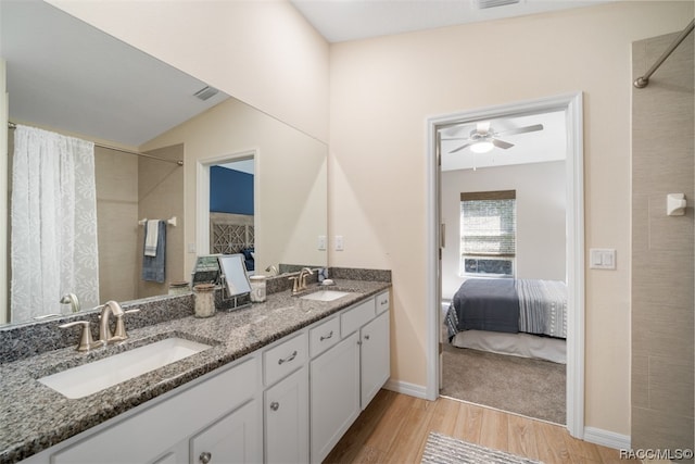 bathroom featuring ceiling fan, wood-type flooring, vanity, and vaulted ceiling