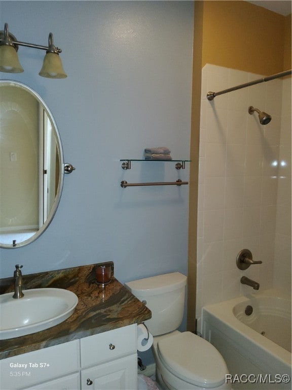 full bathroom featuring toilet, vanity, and tiled shower / bath