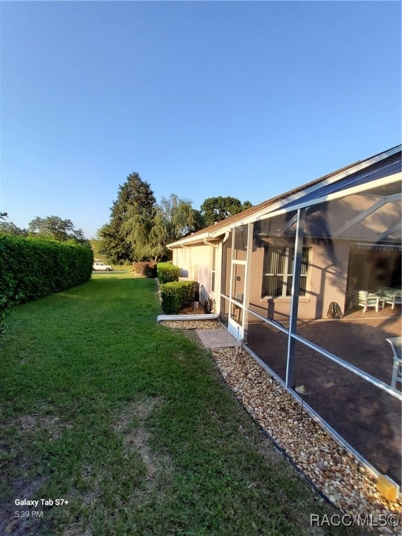 view of yard featuring glass enclosure