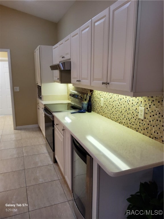 kitchen with white cabinets, stainless steel electric range, light tile patterned floors, and wine cooler