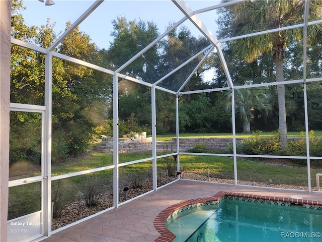 view of swimming pool featuring a patio and a lanai