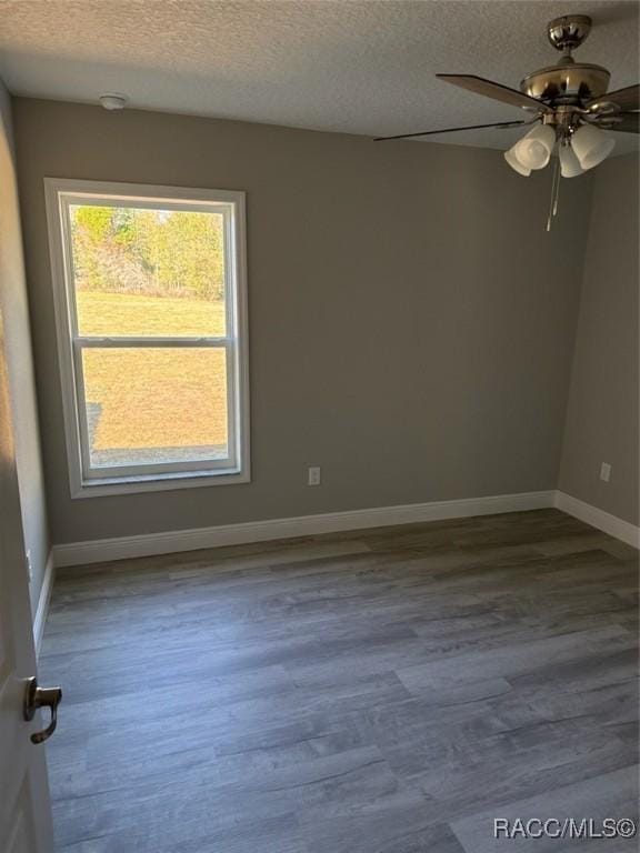 empty room featuring ceiling fan, a textured ceiling, baseboards, and wood finished floors