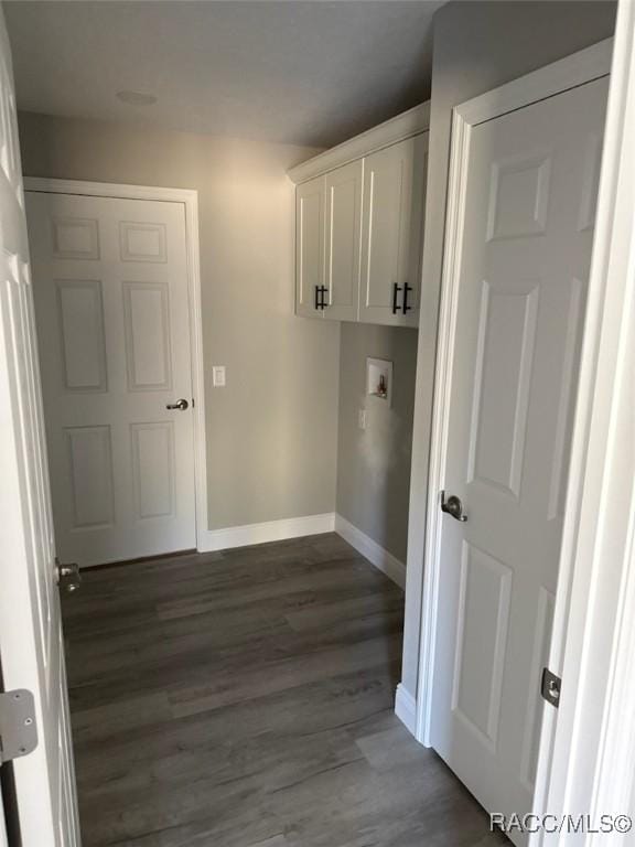 washroom with cabinet space, hookup for a washing machine, baseboards, and dark wood-type flooring