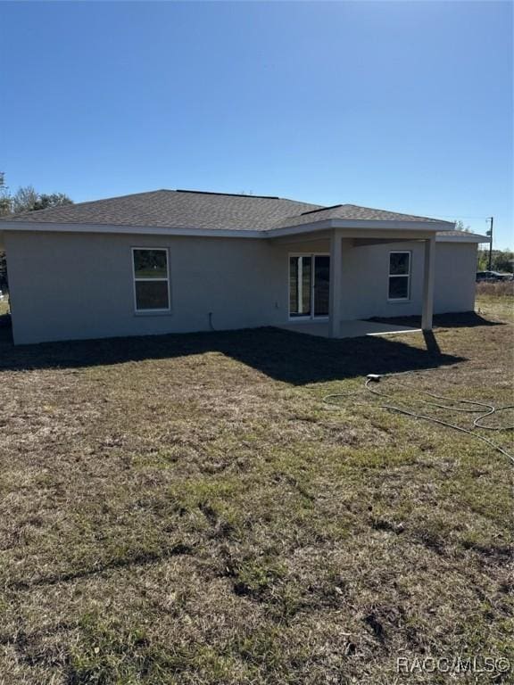 rear view of property with a lawn