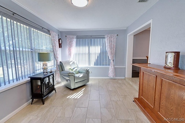 sitting room featuring crown molding and a wood stove