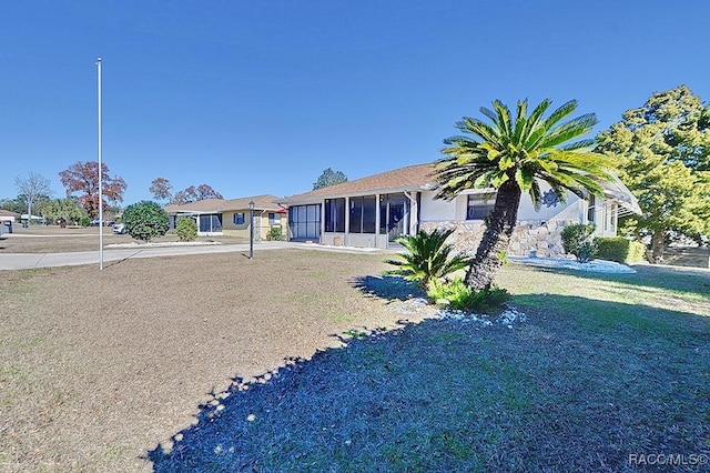 view of front of property with a sunroom and a front lawn