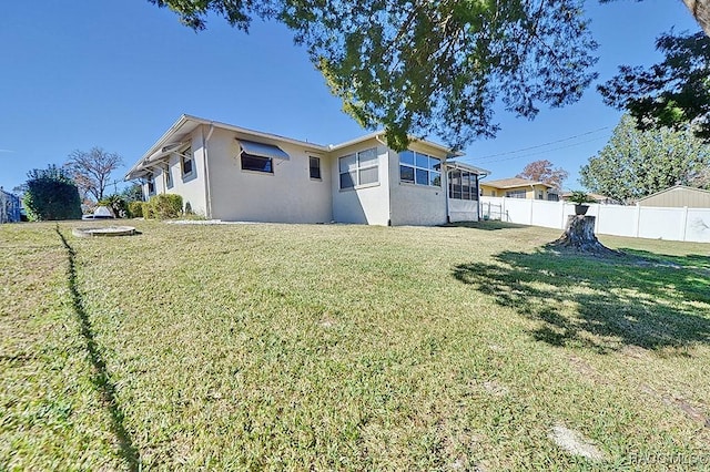 rear view of house featuring a lawn