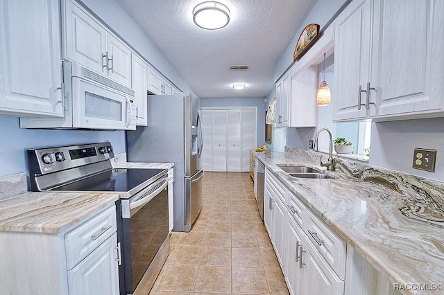 kitchen featuring pendant lighting, stainless steel appliances, white cabinetry, and sink