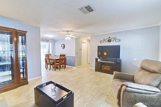 living room with ceiling fan and crown molding