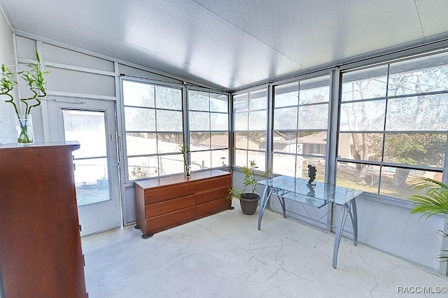 sunroom featuring vaulted ceiling and plenty of natural light