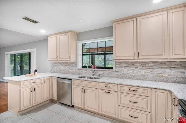 8831 E Sandpiper Dr, Inverness, FL 34450 - kitchen with cream cabinetry, stainless steel dishwasher, a sink, a peninsula, and tasteful backsplash