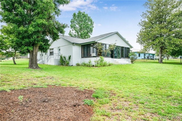 8831 E Sandpiper Dr, Inverness, FL 34450 - view of side of property featuring a lawn and a sunroom