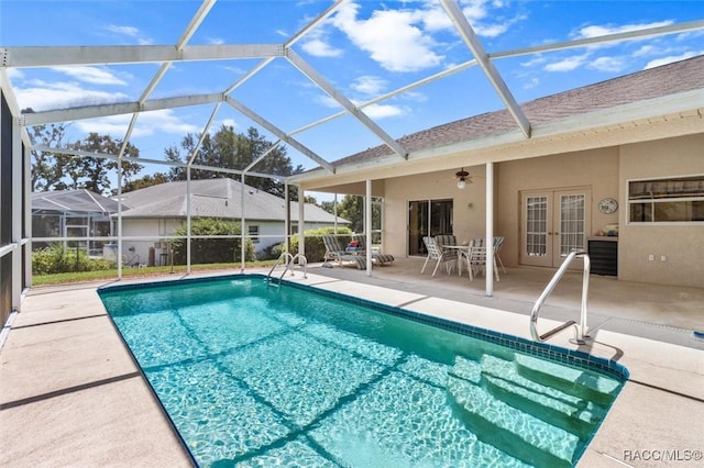 view of pool with french doors, glass enclosure, ceiling fan, and a patio area