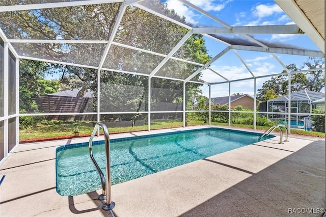 view of pool with a patio area and glass enclosure