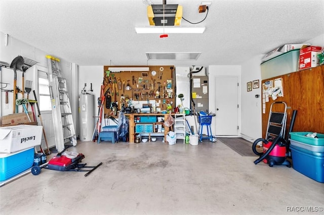 garage with a garage door opener, water heater, and a workshop area