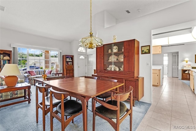 tiled dining space with a high ceiling and a chandelier