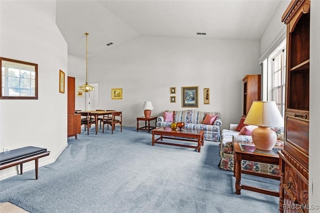 carpeted living room with high vaulted ceiling