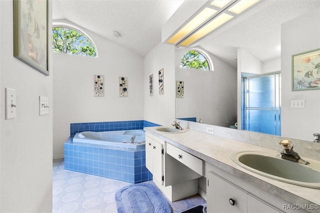 bathroom featuring plus walk in shower, vaulted ceiling, a healthy amount of sunlight, a textured ceiling, and vanity