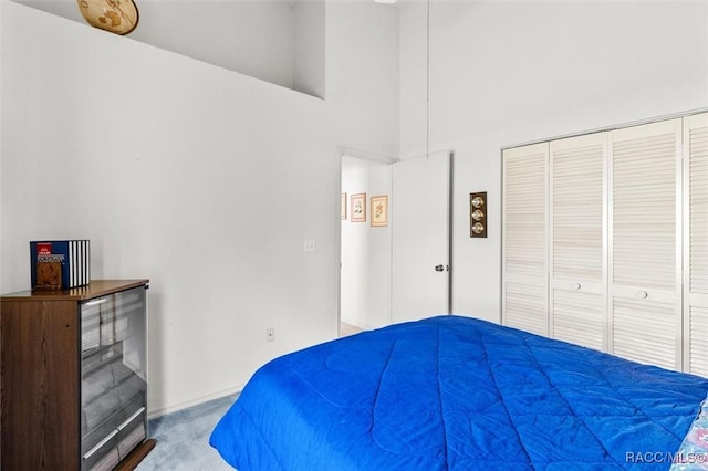 carpeted bedroom with a closet and a towering ceiling