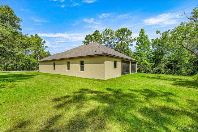 5235 N Sonora Ter, Beverly Hills, FL 34465 - back of property featuring a sunroom, a lawn, and stucco siding