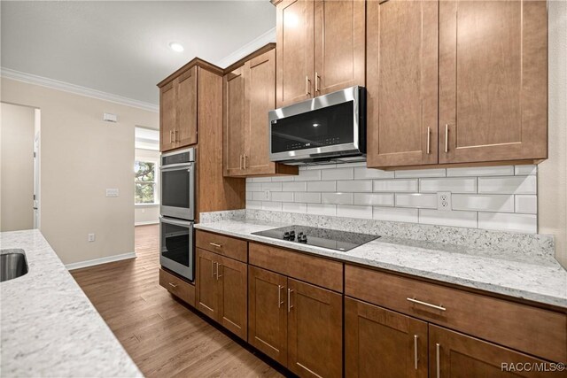 5235 N Sonora Ter, Beverly Hills, FL 34465 - kitchen featuring stainless steel appliances, ornamental molding, dark wood-style flooring, decorative backsplash, and light stone counters