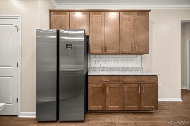5235 N Sonora Ter, Beverly Hills, FL 34465 - kitchen featuring freestanding refrigerator, ornamental molding, tasteful backsplash, wood finished floors, and brown cabinetry