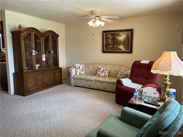 carpeted living room with ceiling fan and a textured ceiling