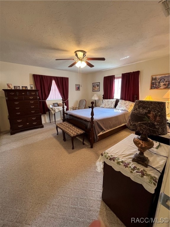 carpeted bedroom featuring a textured ceiling and ceiling fan